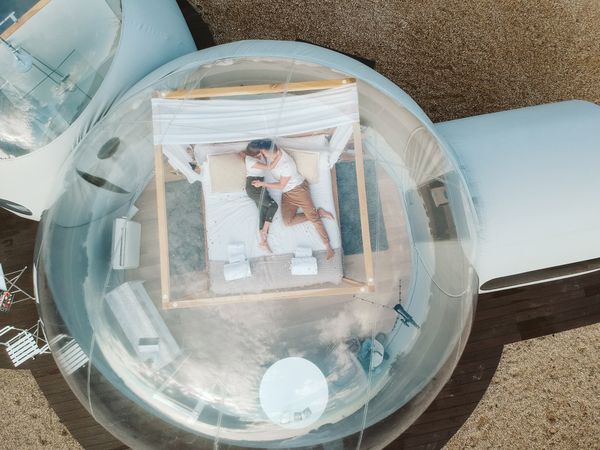 Passionate couple on bed in bubble hotel