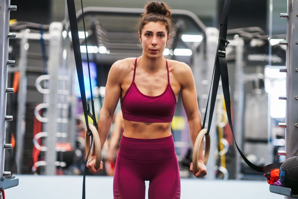 Fit woman on gymnastic hoops at gym
