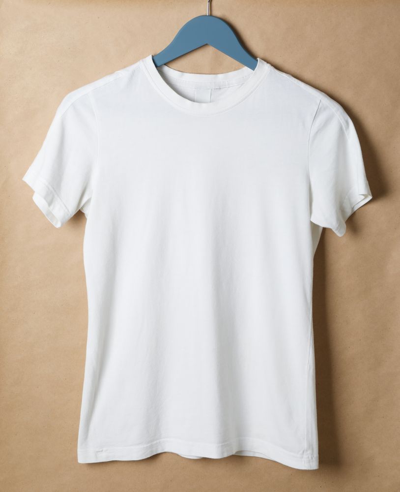 Hanger with blank t-shirt on cardboard background, space for text