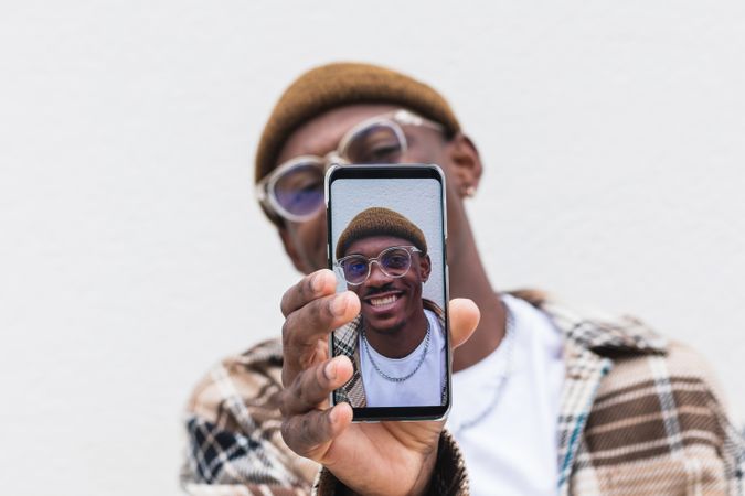 Black guy showing smartphone with self photo