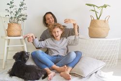 Happy mother with son playing near dog