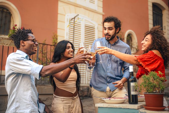 Group of friends toasting with wine at a summer party