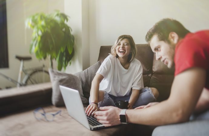 Couple browsing laptop on couch