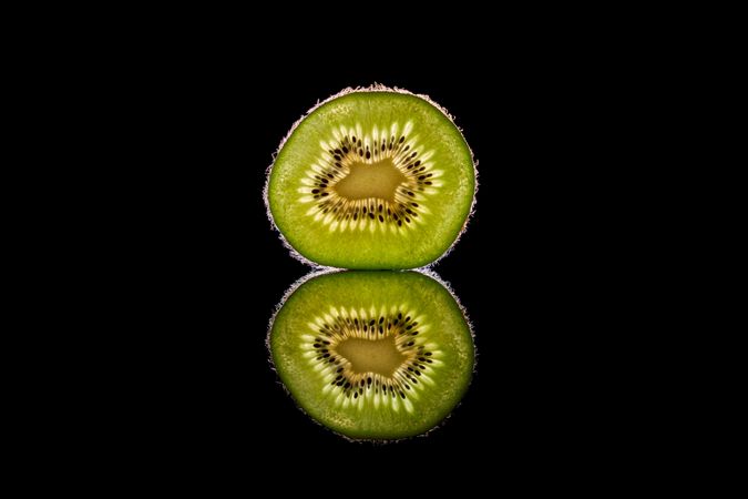 Fresh green kiwi fruit slice in dark studio