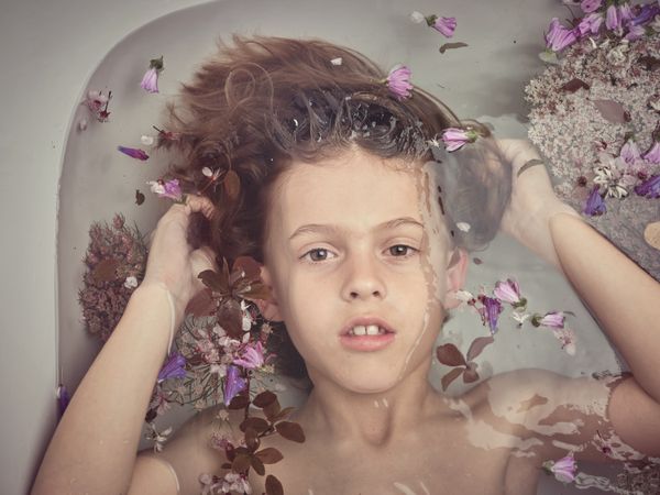Boy lying in water with flowers