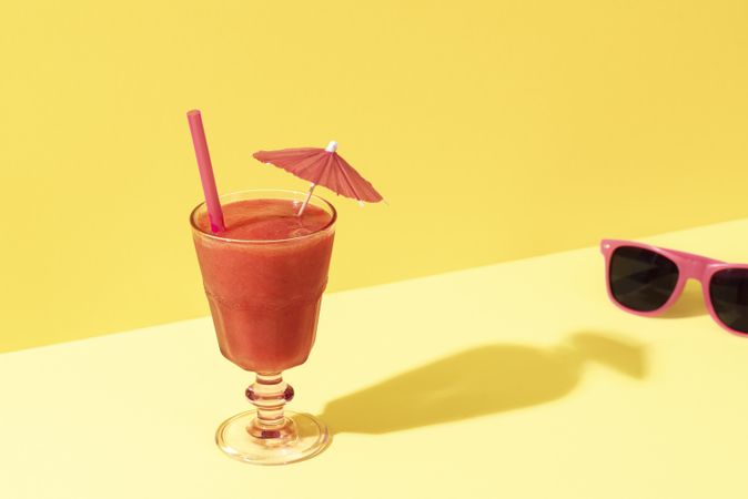 Strawberry smoothie in a glass and pink sunglasses