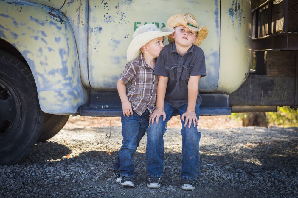Boys Wearing Cowboy Hats Leaning Against Antique Truck.