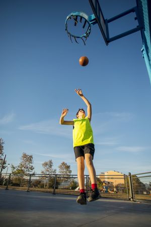 Basketball, teen shooting on basket , in action outdoors