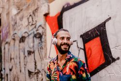 Smiling man listening to music and using smartphone