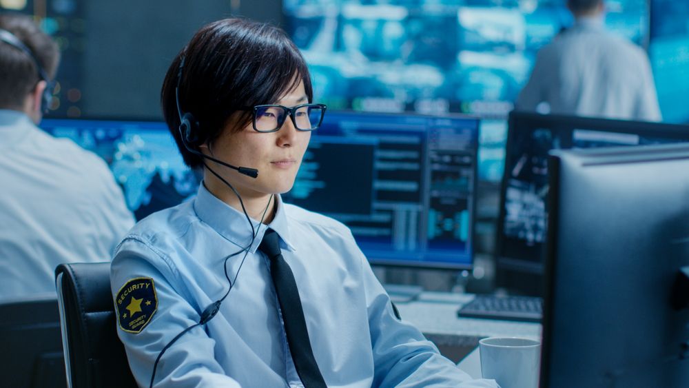 In the Security Command Center Officer at His Workstation Monitors Screens and Communicates with Patrols through Headset.