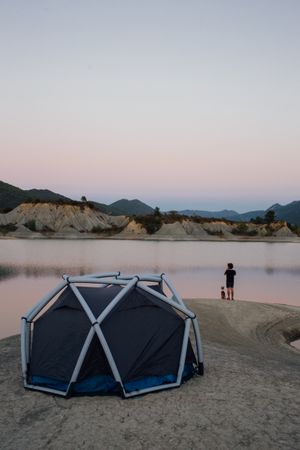 Man and dog camping on a lake