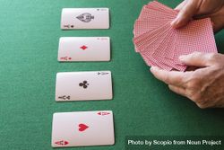 Four aces on table with hands holding playing cards 4mpkB5