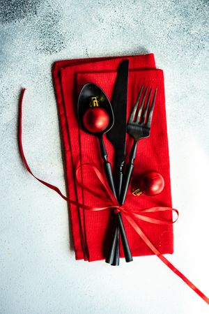 Christmas cutlery wrapped in red napkin and ornaments