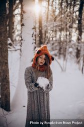 Girl holding snowball in forest 4dkZa5