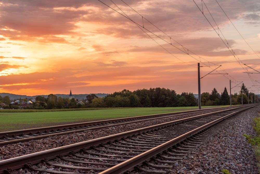 Railroad tracks at sunrise near a german village