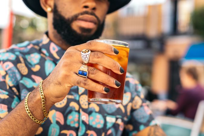 Black man having a drink in a bar terrace