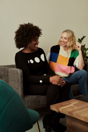 Two women at work sitting on a sofa