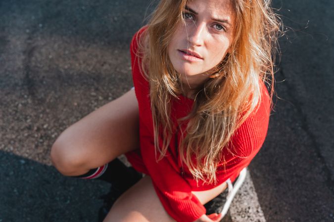 Charming woman in sweater on street between puddles