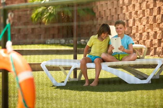 Boys using tablet in garden