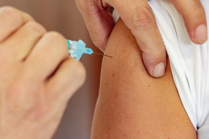 Person injected with coronavirus vaccine by healthcare worker