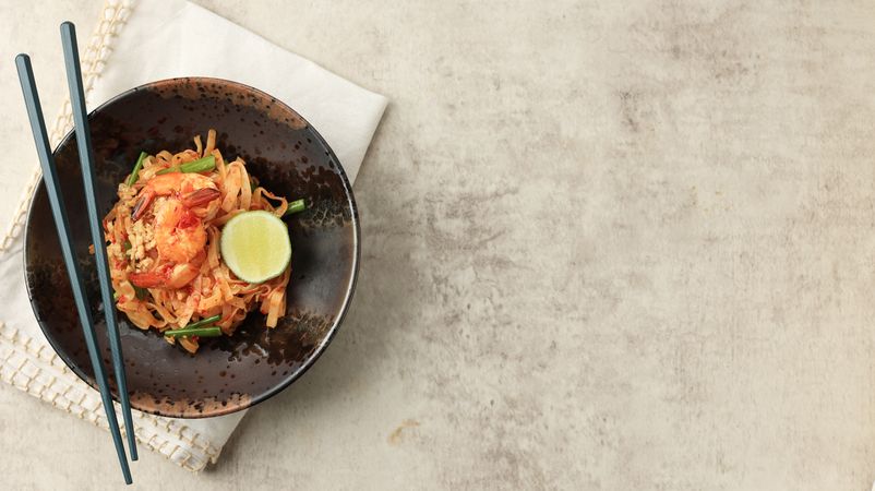 Top view of spicy pad Thai on table with copy space