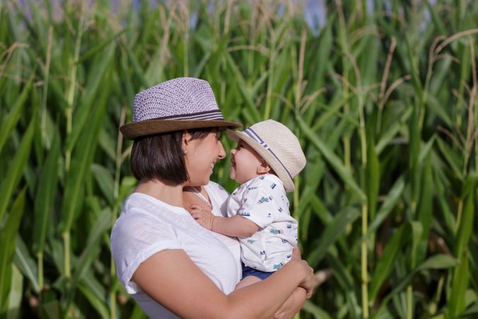 Adorable mother and child on hand enjoying and laughing in field