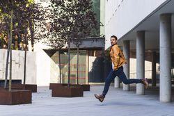 Stylish guy jumping on street