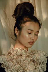 Portrait of young woman in lace floral dress looking down