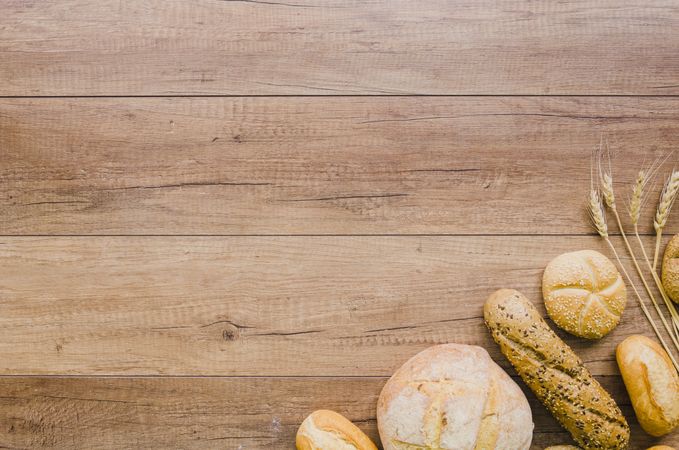 Assortment bread loaves in corner of wooden board