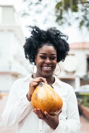 Latin American woman having fun in the city drinking coconuts