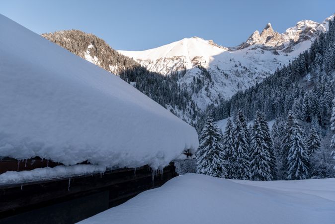 Rustic log cabin covered in deep snow in the Bavarian Alps, in Germany