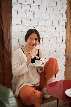 Peaceful woman drinking coffee while resting at home