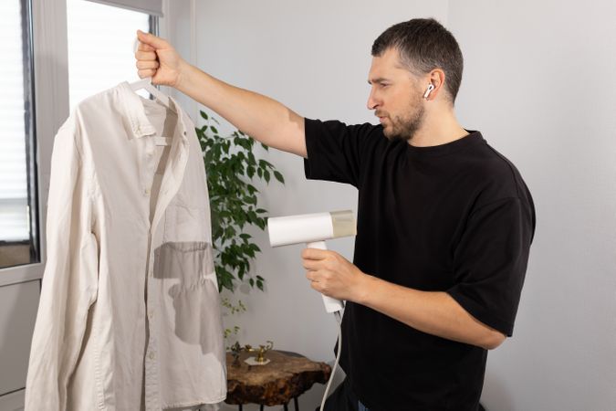 Man Steaming Shirt With Handheld Steamer