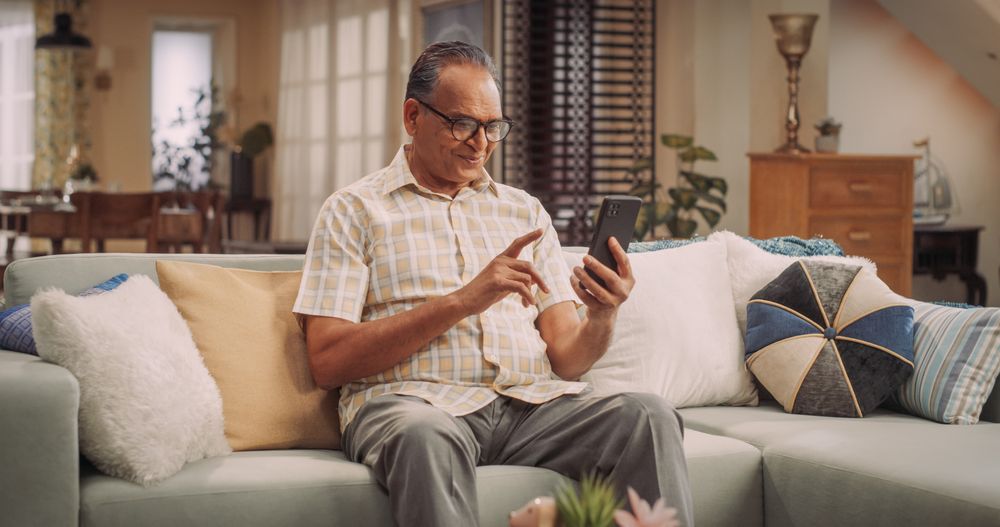 Mature Man Using Smartphone: Staying Informed on Current Events, Participating in Online Discussions, and Expanding Knowledge on Diverse Topics.