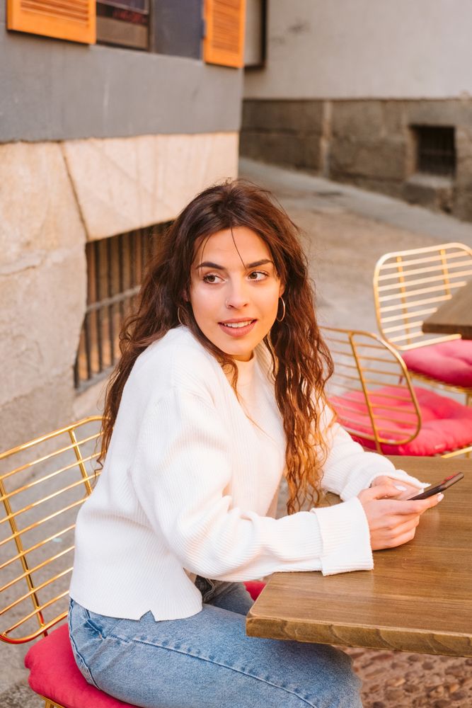 Young woman using smartphone in outdoors cafe