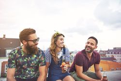 Three friends relaxing on the roof with beer