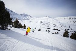 Two snowboarders going down snowy piste in The Alps