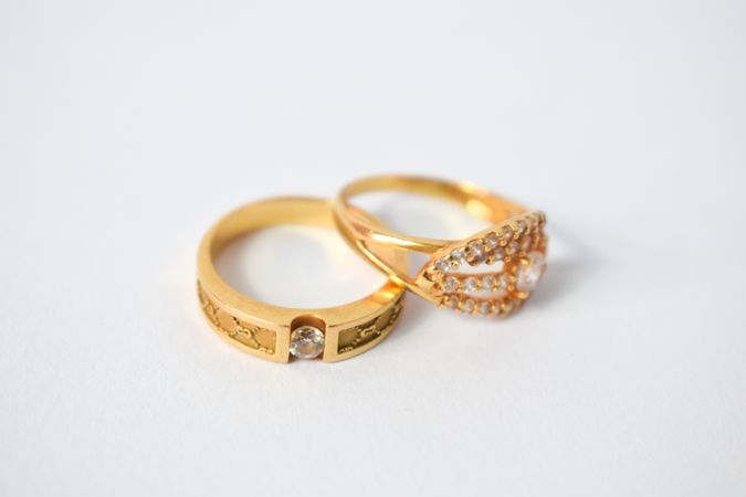 Two diamond gold rings together on plain table