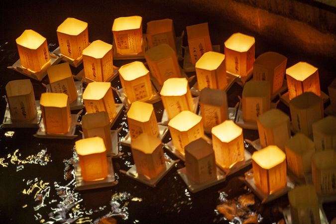 Lit lanterns floating on water at night
