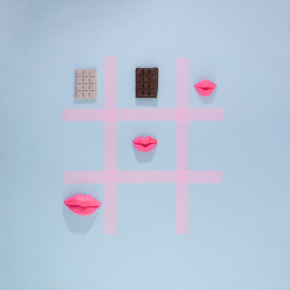 Tic-tac-toe of chocolate bars, hearts, doughnuts, cookies & hearts