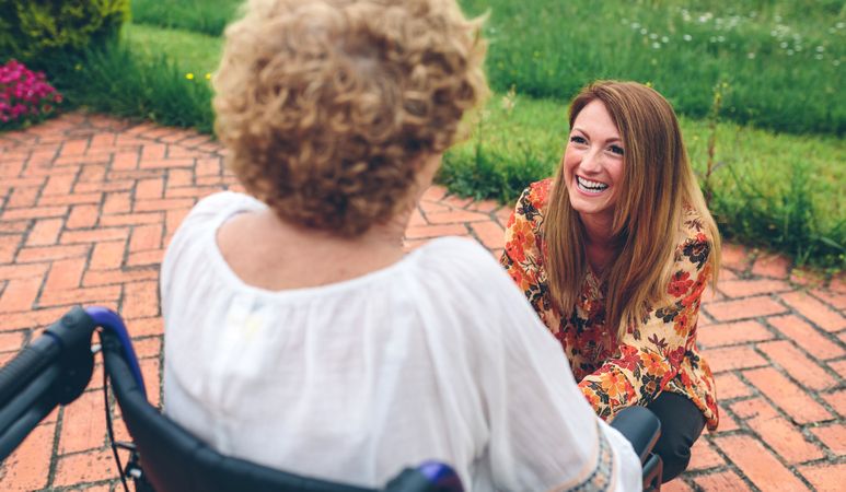Young woman caring for older woman in a wheelchair