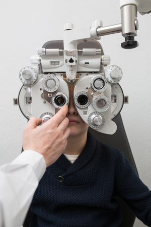 Optician testing a boy's eyes