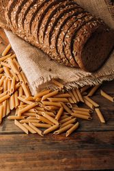 Pasta and freshly baked rye bread on table