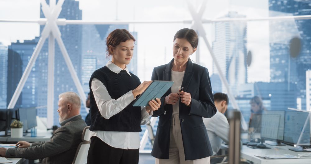 Two Woman Going Through Schedule and Business Meetings On Tablet In Fintech Startup.