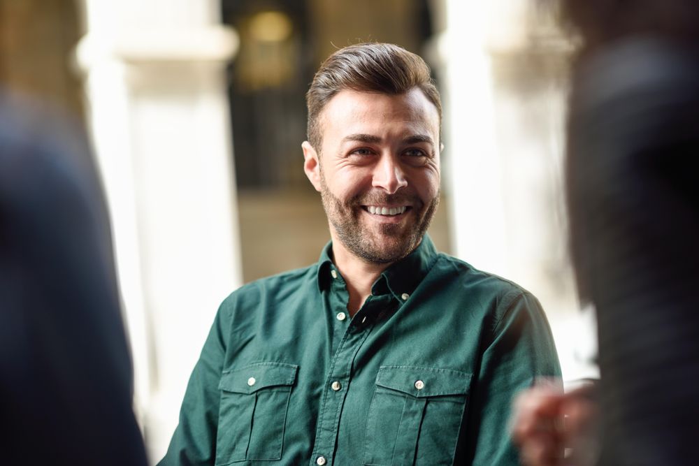Man sitting at cafe, talking with friends