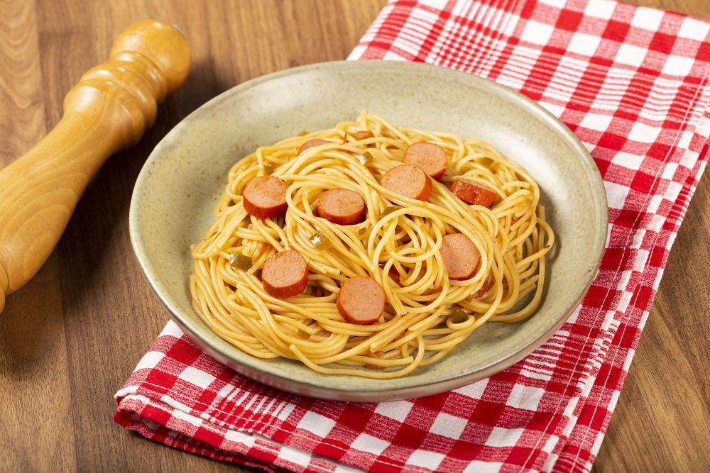 spaghetti pasta with sliced sausages and tomato sauce.