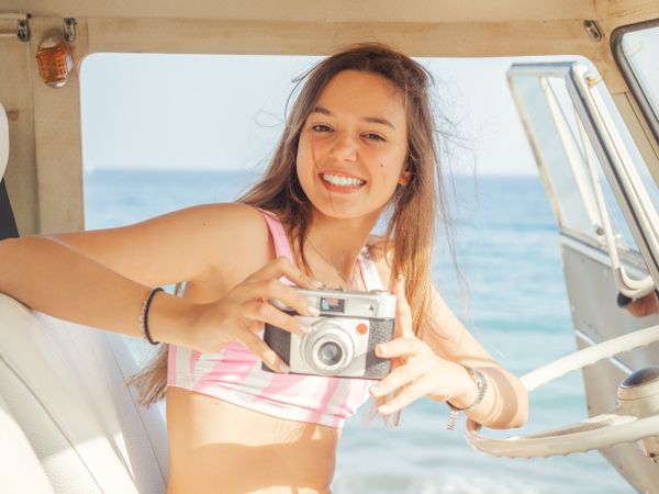 Woman taking photo in front seat of car