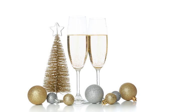 Champagne glasses and baubles isolated on light background