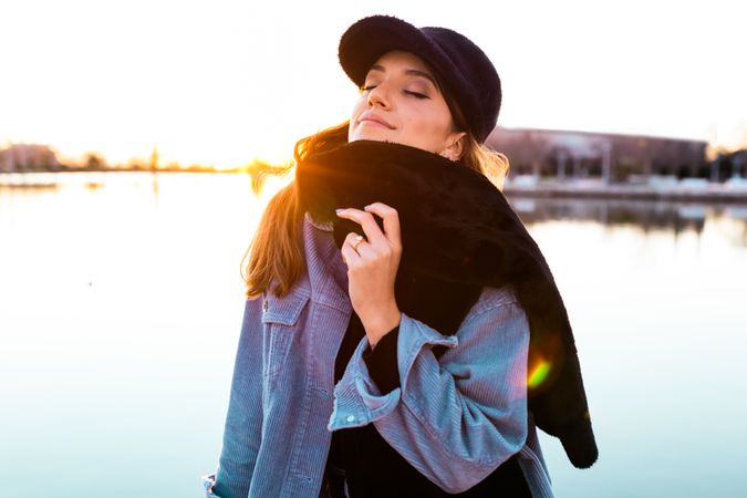 Charming woman in casual wear on shore of lake