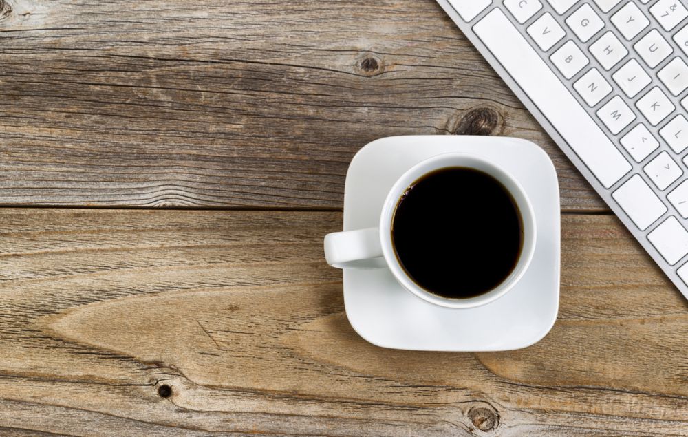 Coffee with partial computer keyboard for school or office on rustic wooden boards